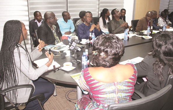 Madam Valentina Mintah, sitting at head of table and explaining some points to the Parliamentary Select Committee